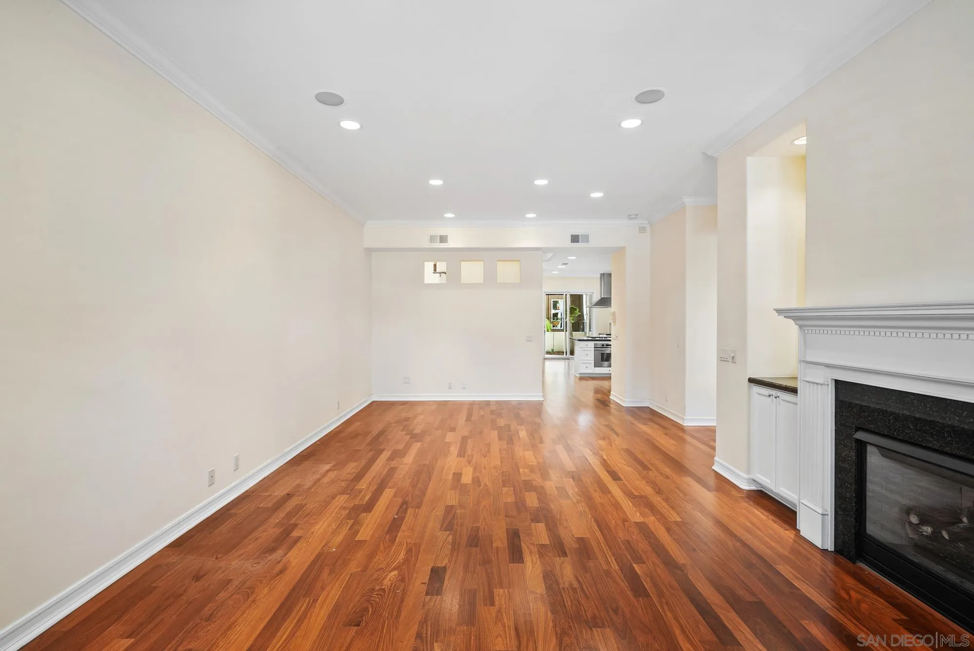 7836 Ivanhoe Avenue La Jolla, CA 92037 - Photo 5 of 31 a view of empty room with wooden floor and fireplace