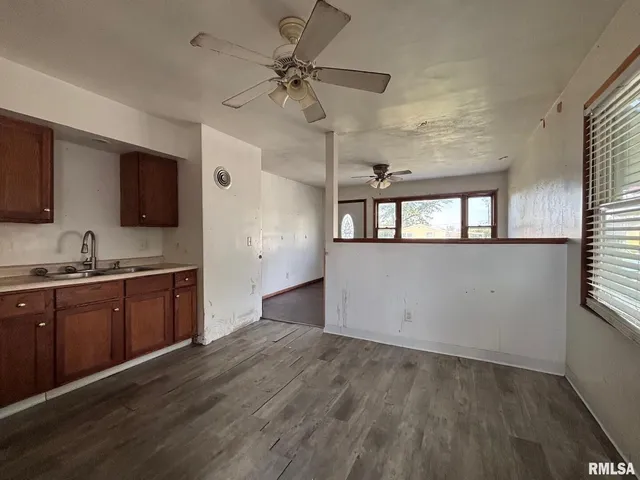 a kitchen with granite countertop a stove a sink and a refrigerator