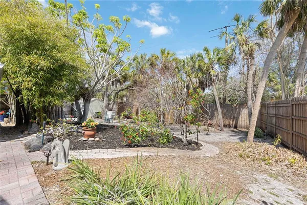 a view of backyard with wooden fence and trees