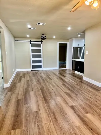 a view of empty room with wooden floor and windows