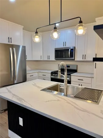 a kitchen with stainless steel appliances a refrigerator a sink and a stove