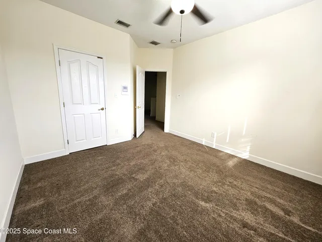 an empty room with a ceiling fan and a window