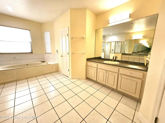 a large white kitchen with a sink and cabinets