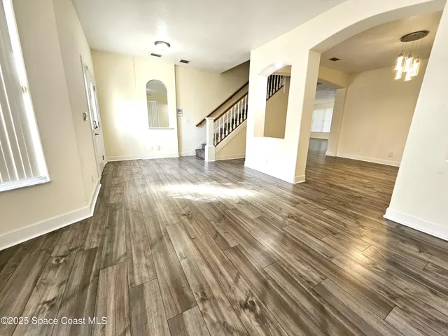 a view of a hallway view with wooden floor and staircase