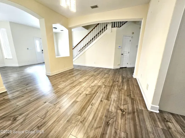 a view of a hallway view with wooden floor and staircase