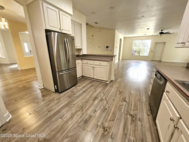 a kitchen with stainless steel appliances a refrigerator and wooden floor