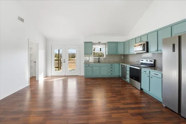 a kitchen with stainless steel appliances granite countertop a refrigerator and a sink