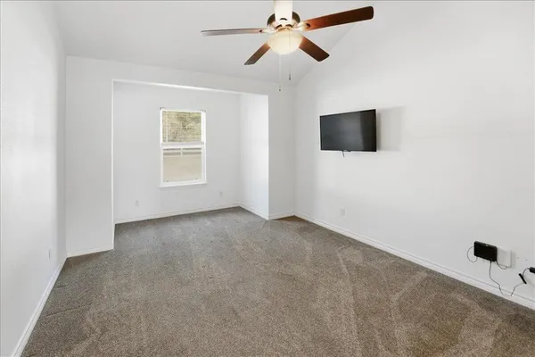 a view of a livingroom with a ceiling fan and window