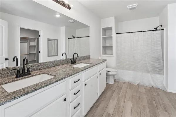 a bathroom with a granite countertop sink toilet and shower