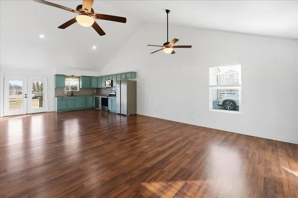 a view of a room with wooden floor and a ceiling fan