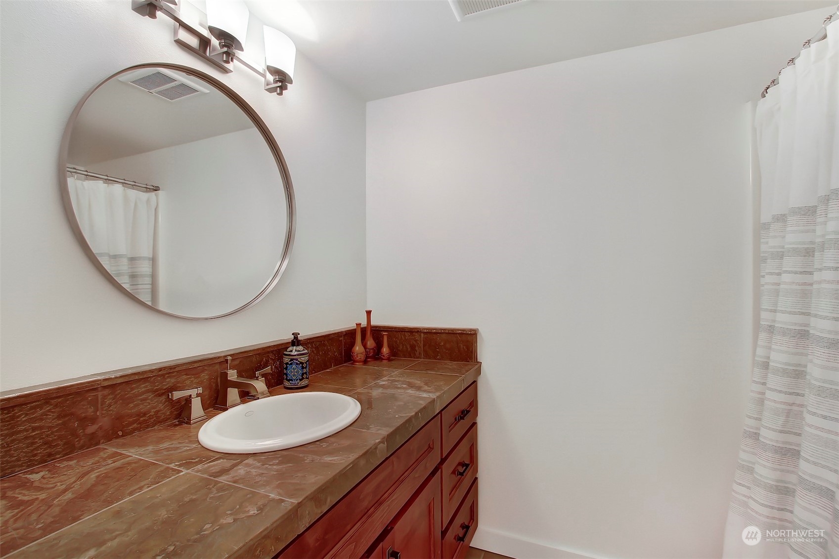 2733 49th Avenue Southwest Seattle, WA 98116 - Photo 25 of 32 a bathroom with a sink and a mirror