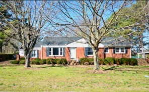 a front view of house with yard and trees around