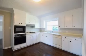 a kitchen with granite countertop white cabinets and white appliances