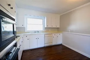 a kitchen with granite countertop white cabinets and white appliances