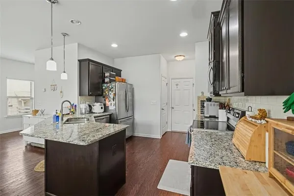 a kitchen with sink refrigerator and microwave