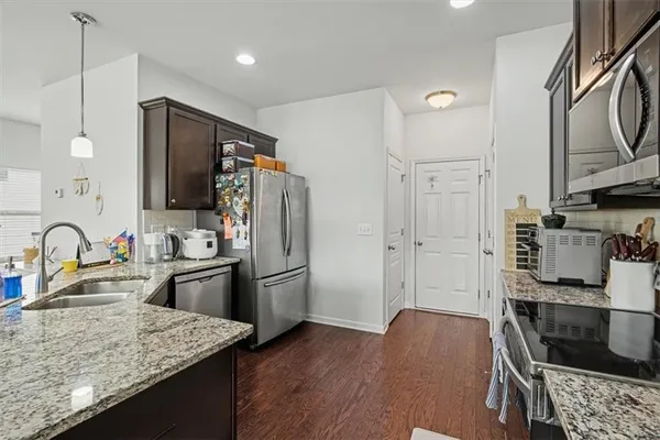 a kitchen with stainless steel appliances granite countertop a refrigerator stove and sink