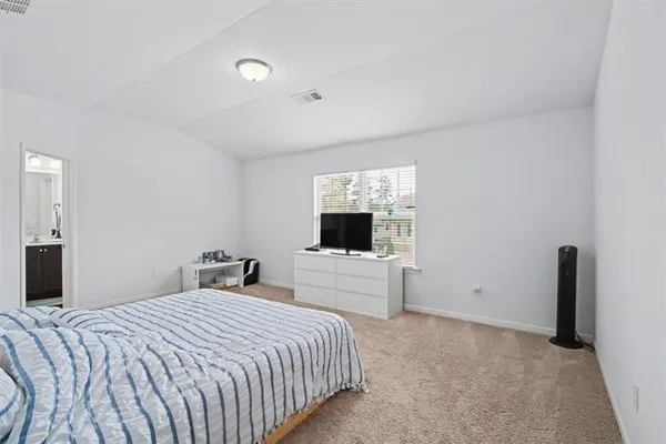 a bedroom with a large bed and a flat screen tv