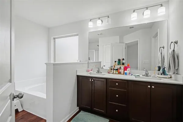 a bathroom with a sink vanity tub and a mirror