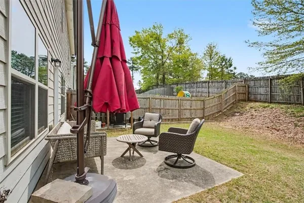 a view of a chairs and fire pit in the backyard of a house