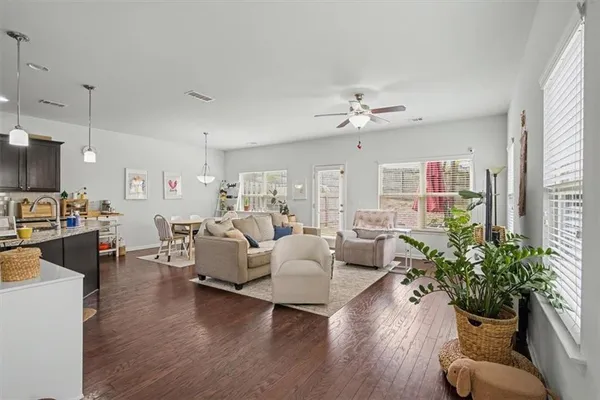a living room with furniture or chandelier and a wooden floor