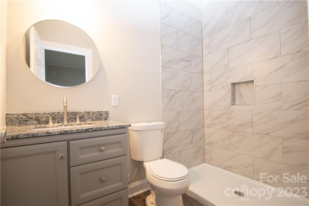 1257 Springdale Road Lancaster, SC 29720 - Photo 13 of 18 a bathroom with a granite countertop toilet sink mirror and vanity