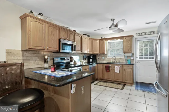 a kitchen with stainless steel appliances granite countertop a stove sink and cabinets
