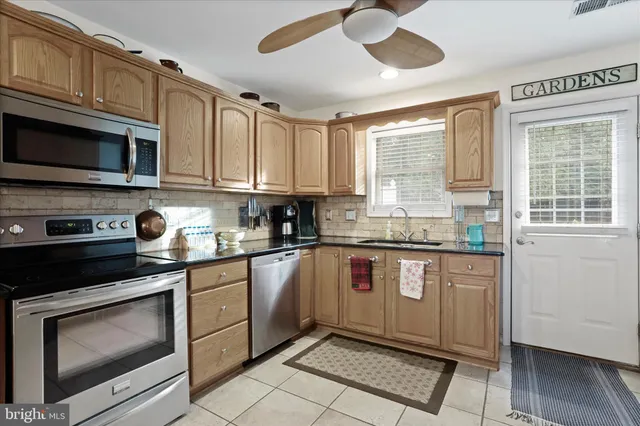 a kitchen with stainless steel appliances granite countertop a stove sink microwave and cabinets