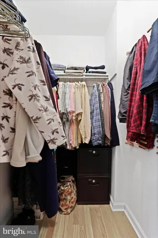 a view of walk in closet with clothes and shoes