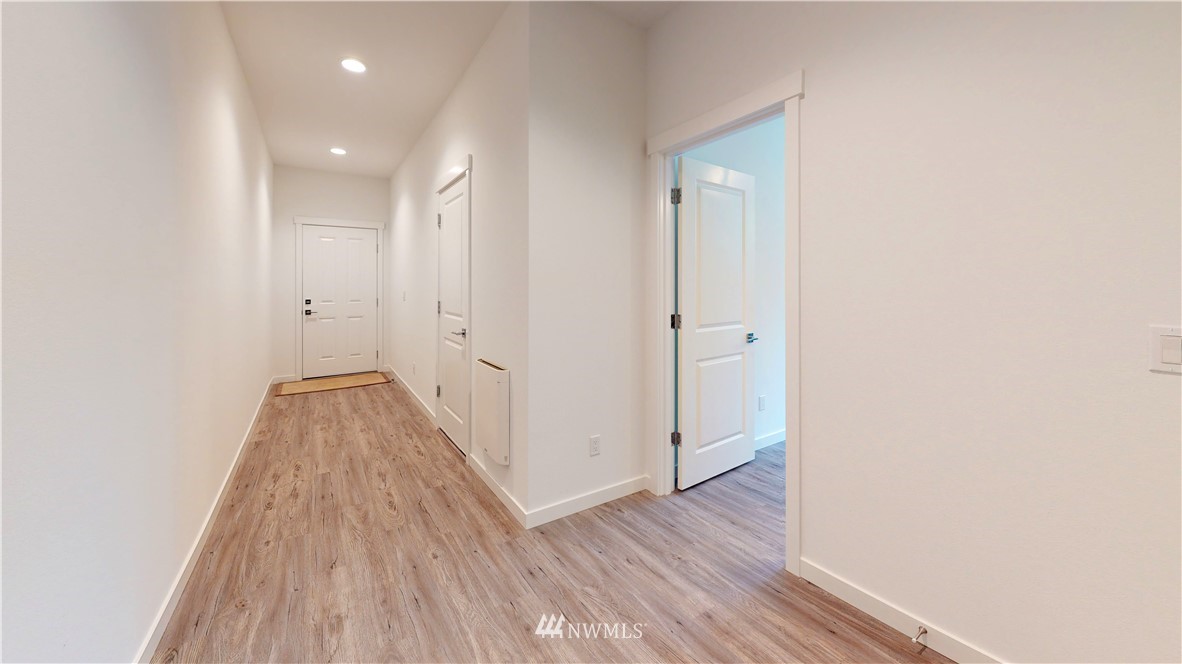 4865 Talbot Road South, Unit B4 Renton, WA 98055 - Photo 31 of 33 a view of a hallway with wooden floor and a bathroom
