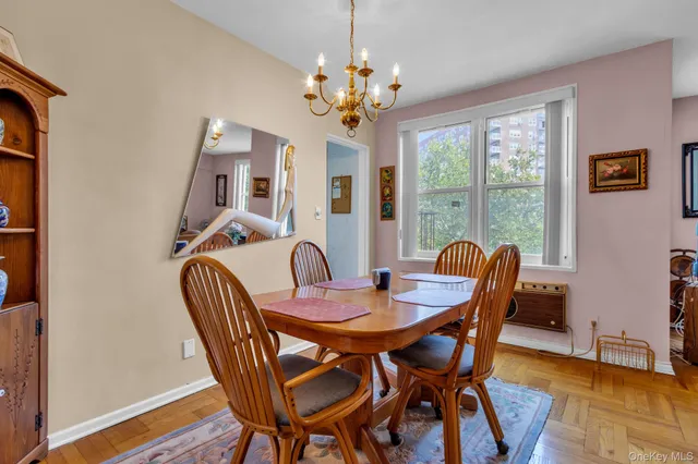a view of a dining room with furniture a chandelier and wooden floor