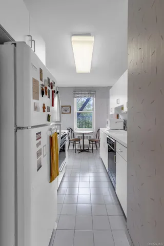 a kitchen with stainless steel appliances a refrigerator a sink a stove and white cabinets