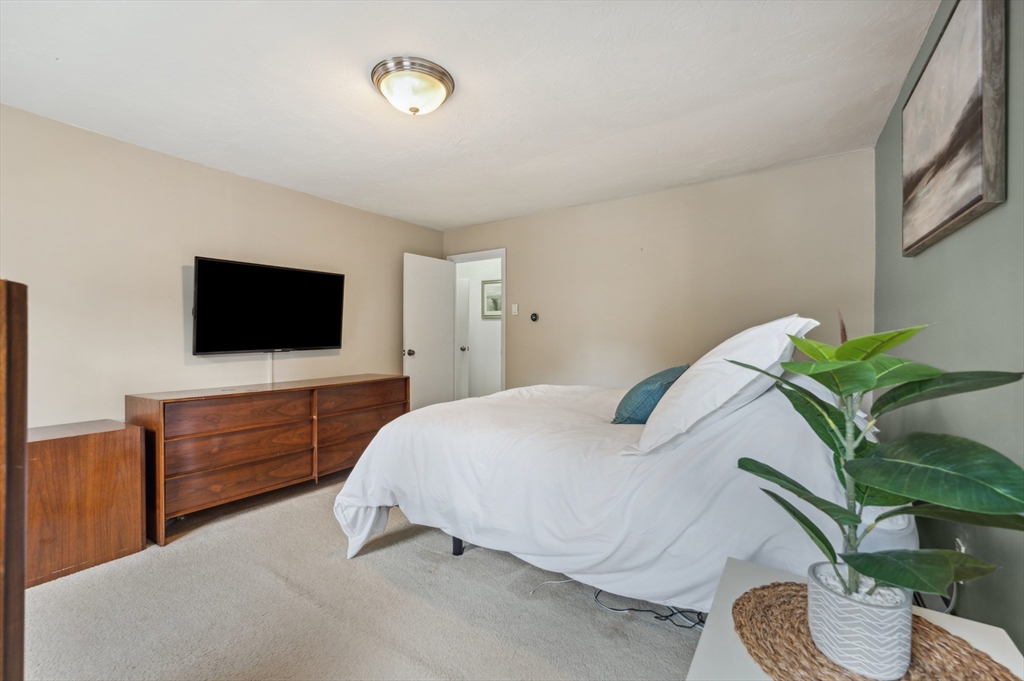 128 Pleasant Street Franklin, MA 02038 - Photo 12 of 19 a bedroom with a bed and flat screen tv