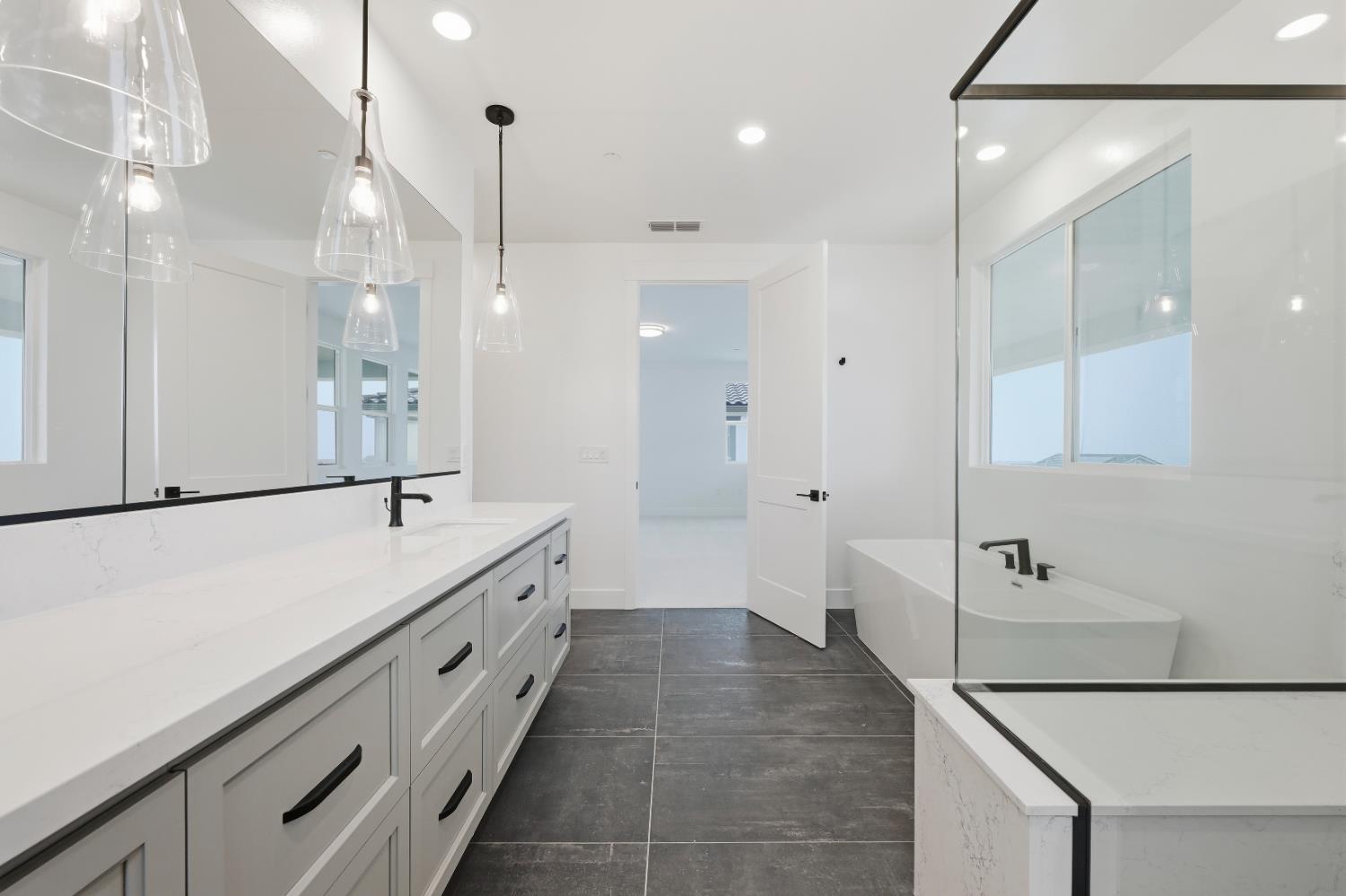 3034 Sidewinder Loop Rocklin, CA 95765 - Photo 35 of 37 a large white bathroom with a large mirror sink and bathtub