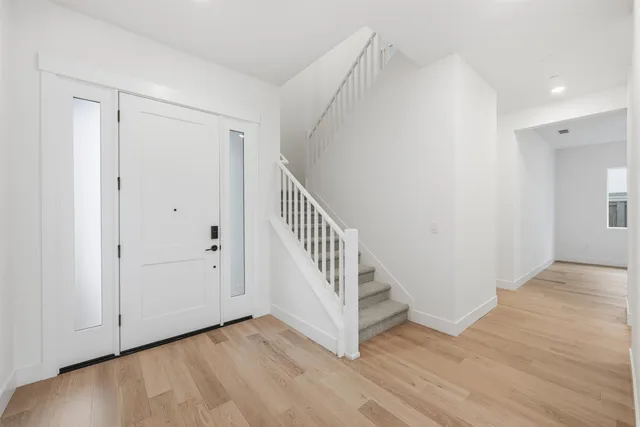 a large kitchen with stainless steel appliances a sink a stove a refrigerator and cabinets