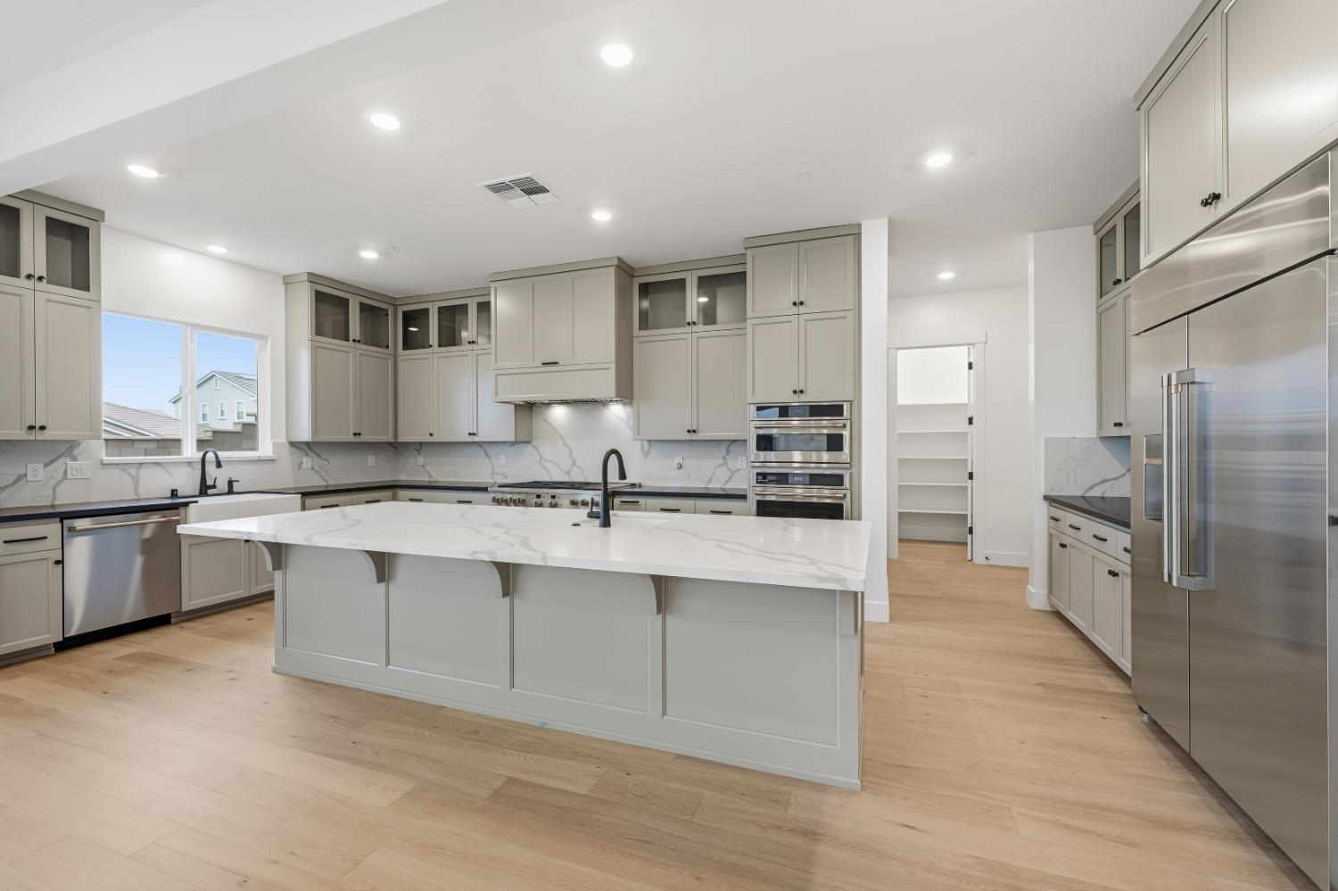 3034 Sidewinder Loop Rocklin, CA 95765 - Photo 9 of 37 a large kitchen with stainless steel appliances a sink a stove a refrigerator and cabinets