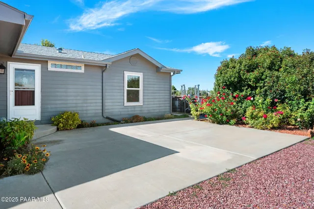 a backyard of a house with flower plants