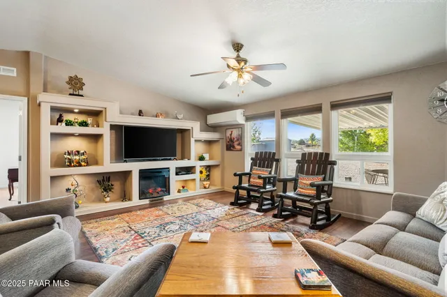 a living room with furniture a flat screen tv and a large window