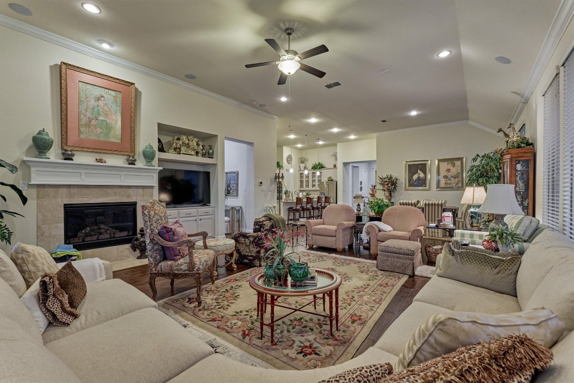 7430 Kearney Hill Lane Spring, TX 77389 - Photo 12 of 47 Spacious living room featuring a cozy fireplace, built-in cabinetry, and an open layout that flows seamlessly into the kitchen. Abundant natural light and elegant finishes create a warm and inviting space perfect for gathering and entertaining.