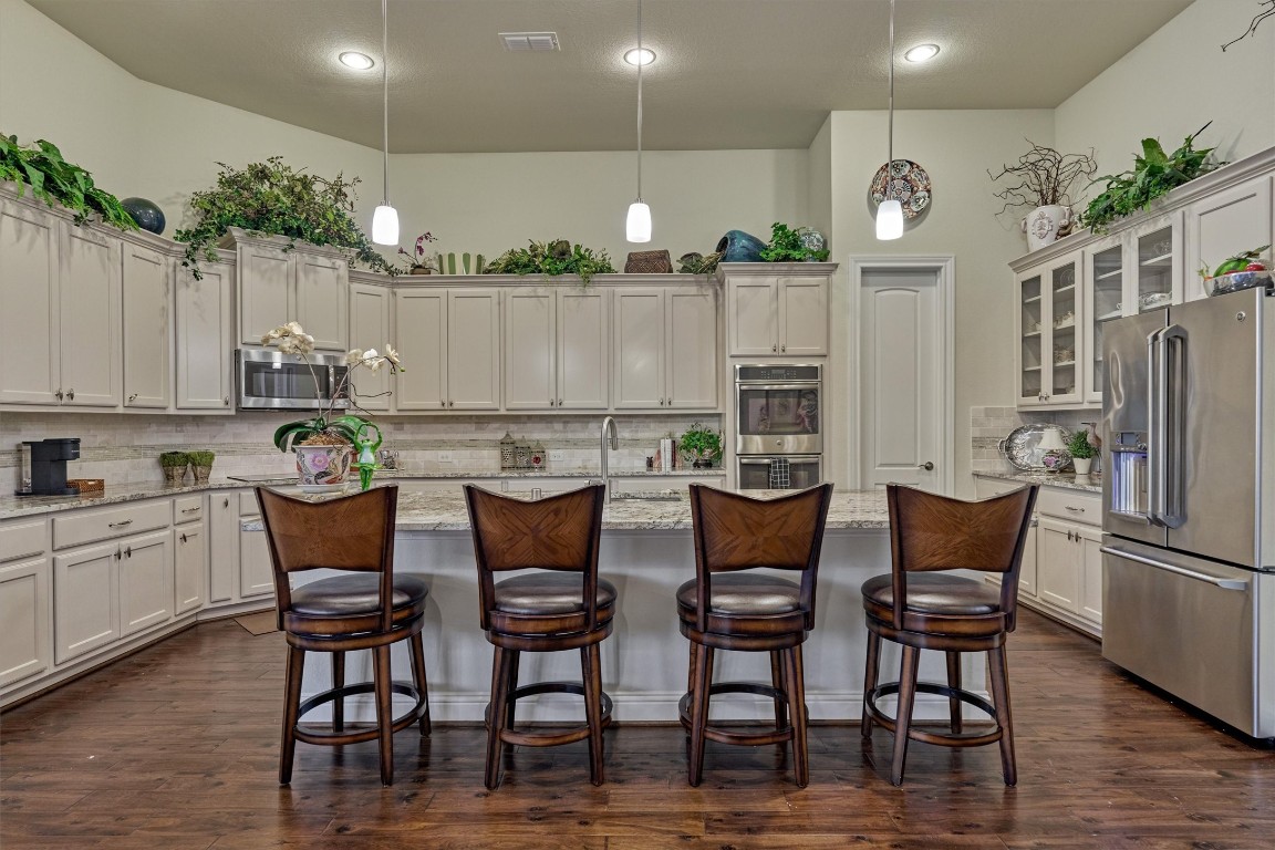 7430 Kearney Hill Lane Spring, TX 77389 - Photo 17 of 47 Spacious kitchen with a large granite island and bar seating, ideal for gathering and entertaining. Features include stainless steel appliances, abundant cabinetry, walk in pantry and an open, airy design with high ceilings.