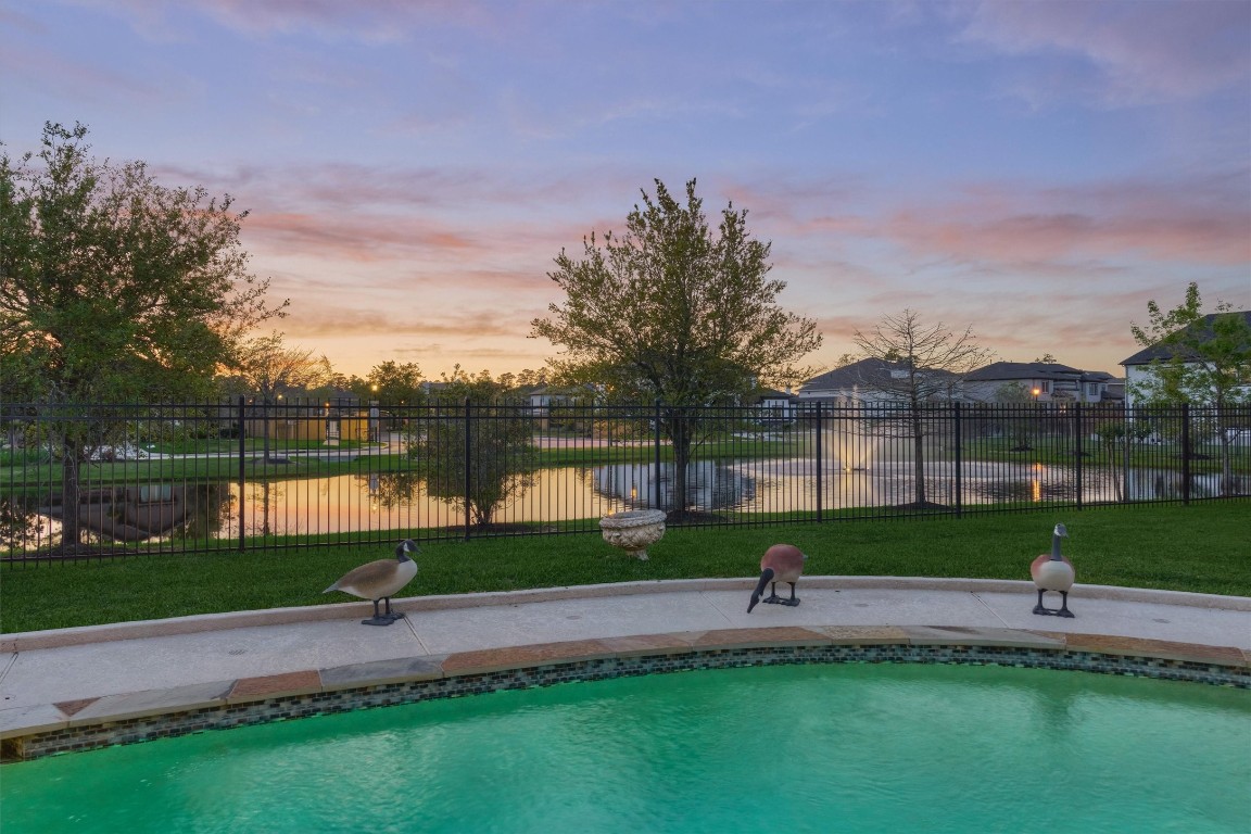 7430 Kearney Hill Lane Spring, TX 77389 - Photo 2 of 47 Resort-style backyard with a sparkling pool overlooking a tranquil pond and no back neighbors. Enjoy stunning sunset views that create the perfect setting for relaxing or entertaining outdoors.