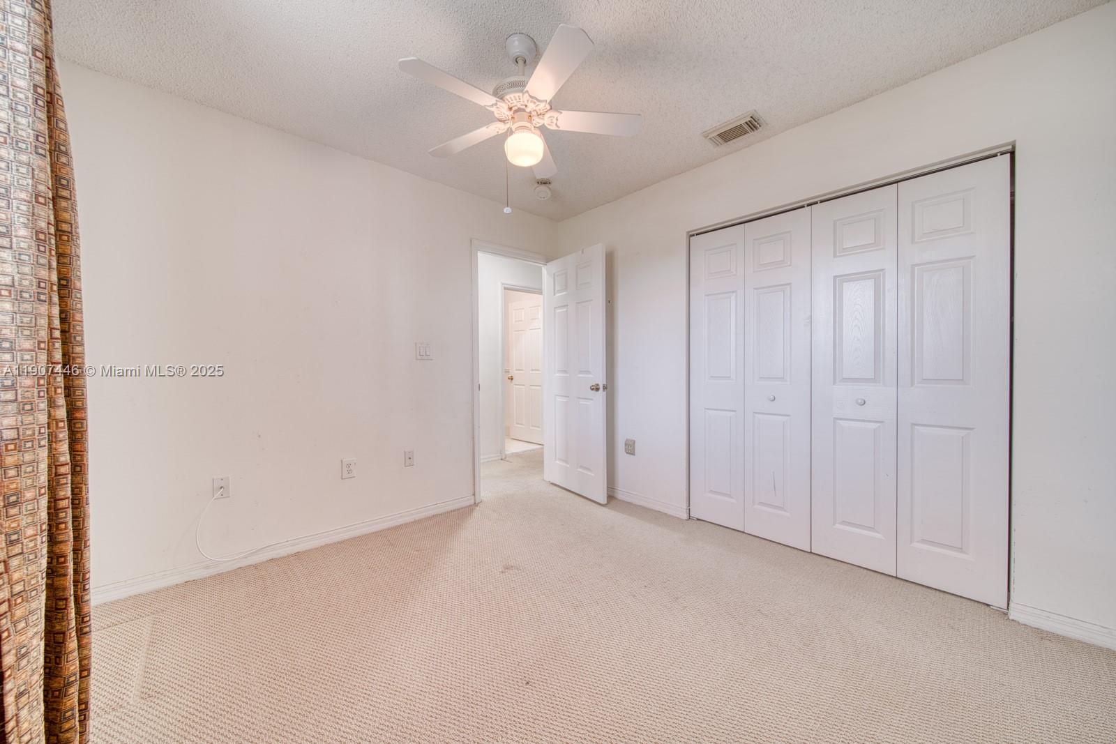 16394 Southwest 75th Street Miami, FL 33193 - Photo 25 of 35 an empty room with a ceiling fan and a window