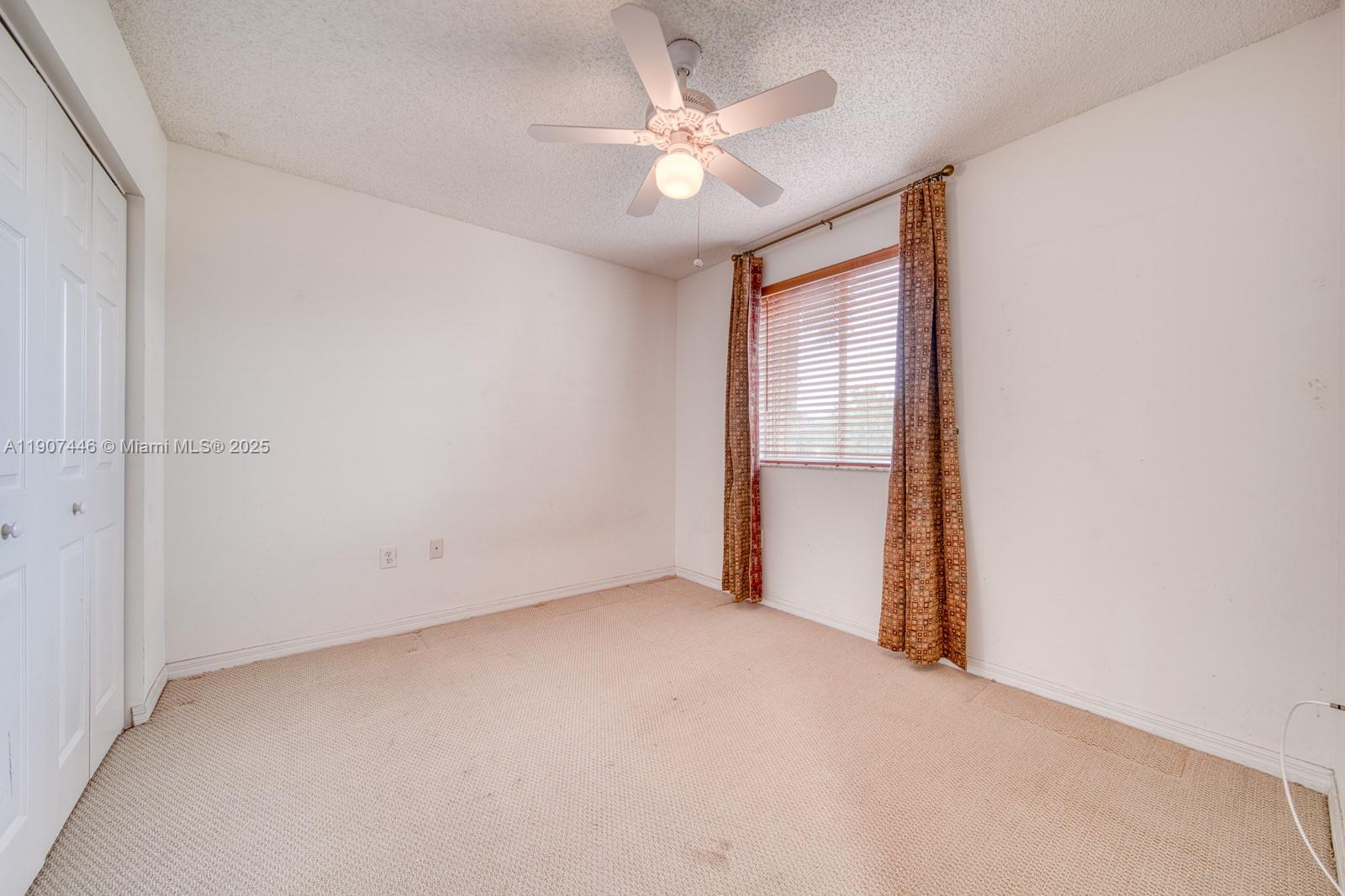 16394 Southwest 75th Street Miami, FL 33193 - Photo 26 of 35 an empty room with a ceiling fan and a window
