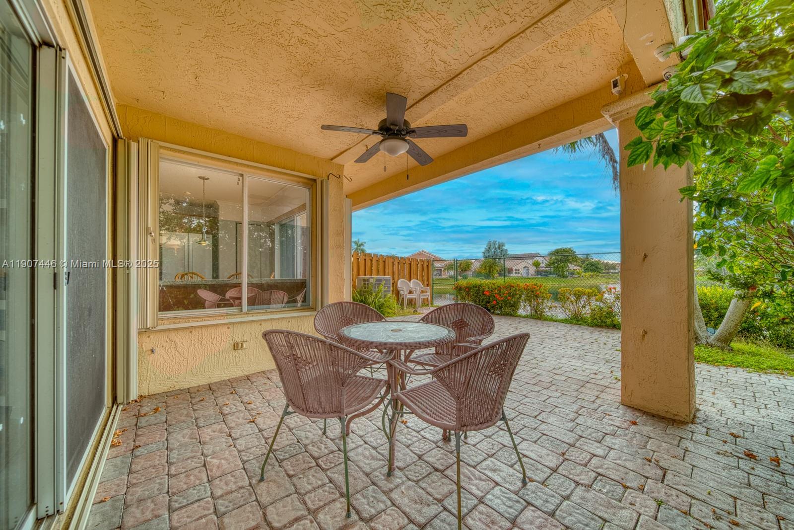 16394 Southwest 75th Street Miami, FL 33193 - Photo 32 of 35 a view of a patio with a table and chairs next to a yard