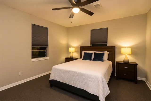 a bedroom with a bed and a lamp on the dresser