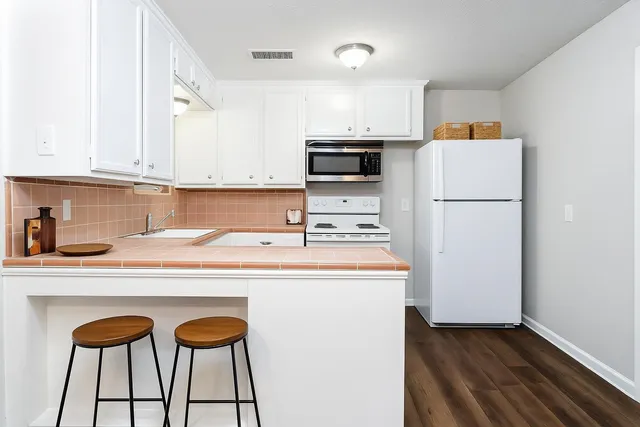 a kitchen with stainless steel appliances a refrigerator and a stove top oven