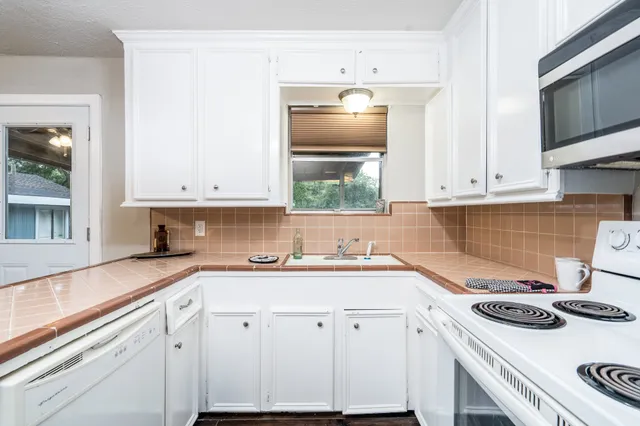 a kitchen with a sink a stove and cabinets