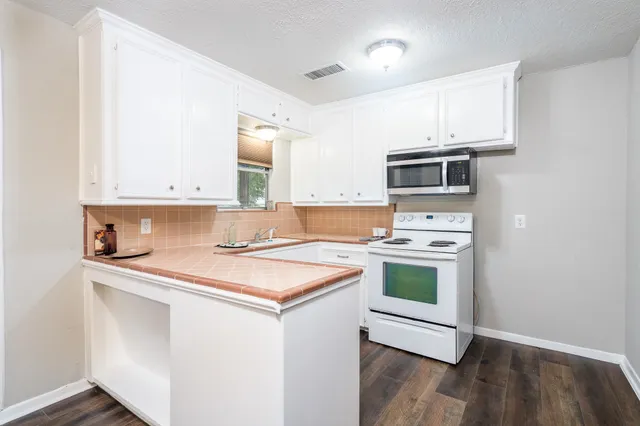 a kitchen with a stove a sink and a microwave