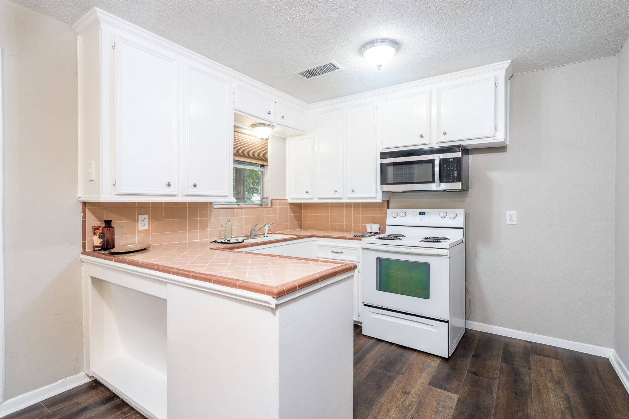 503 Carrell Street Tomball, TX 77375 - Photo 3 of 31 a kitchen with a stove a sink and a microwave