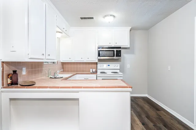a kitchen with stainless steel appliances a sink stove and cabinets