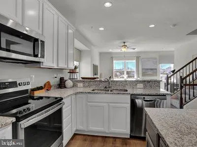 a kitchen with stainless steel appliances granite countertop a stove and a microwave